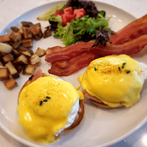 image of eggs benedict, bacon, hashbrowns and salad