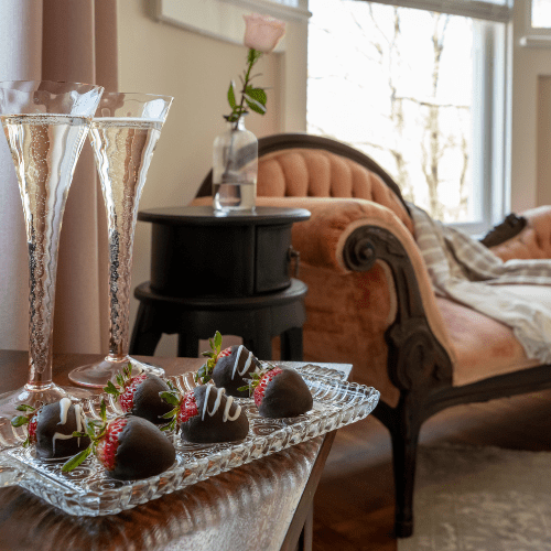 Port_Austin_Bed_and_breakfast_Port_Austin_Bed_and_Breakfast_Champagne - Port Austin Bed & Breakfast Champagne glasses and chocolate covered strawberries on a table near a fainting couch