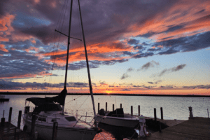 Port_Austin_Bed_and_Breakfast_Port_Austin_Michigan_Hotel_Image 20 - Port Austin Bed & Breakfast Sailboat docked in a harbor at sunset